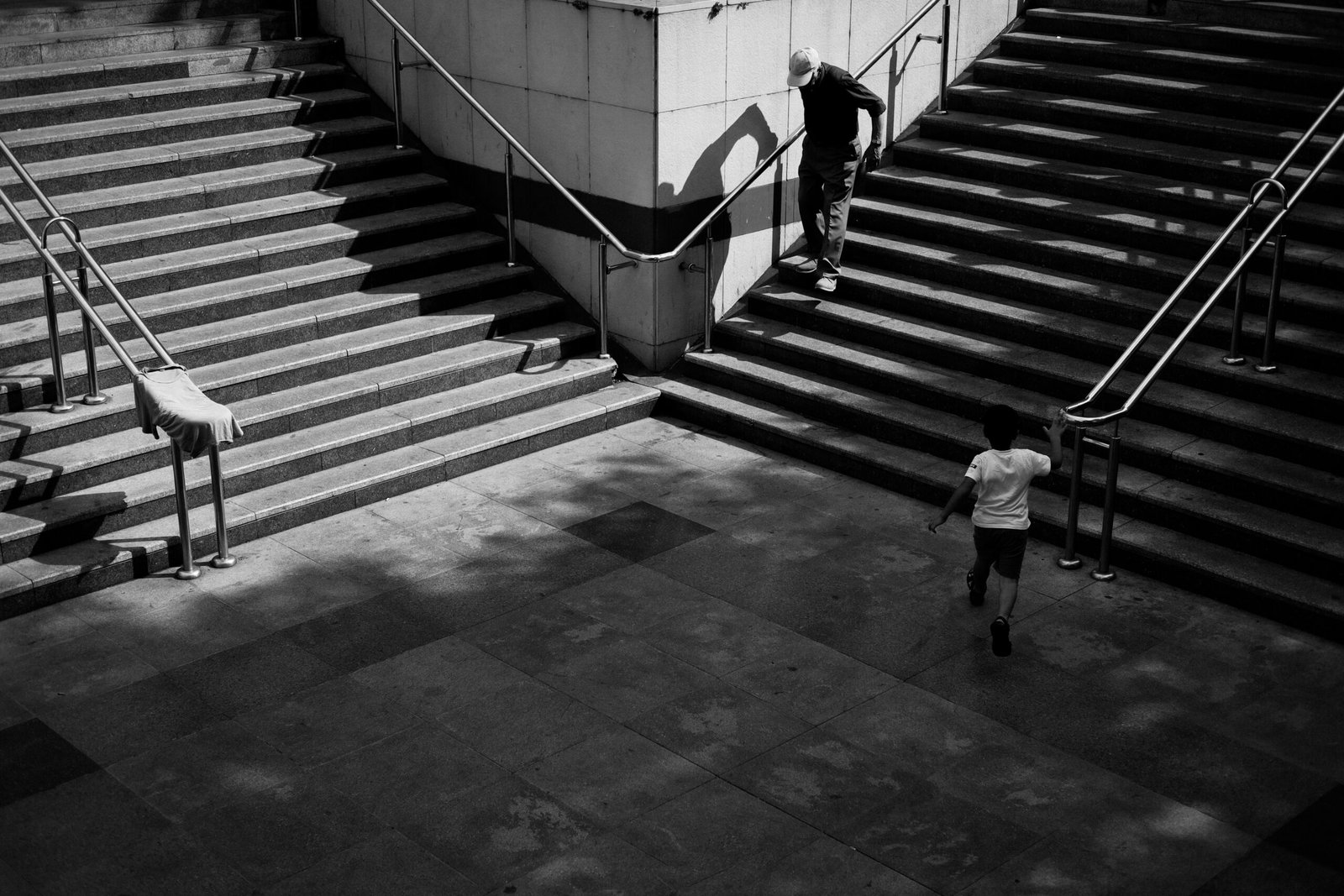 A captivating black and white scene of a child and elderly man on stairs in İstanbul, Türkiye.